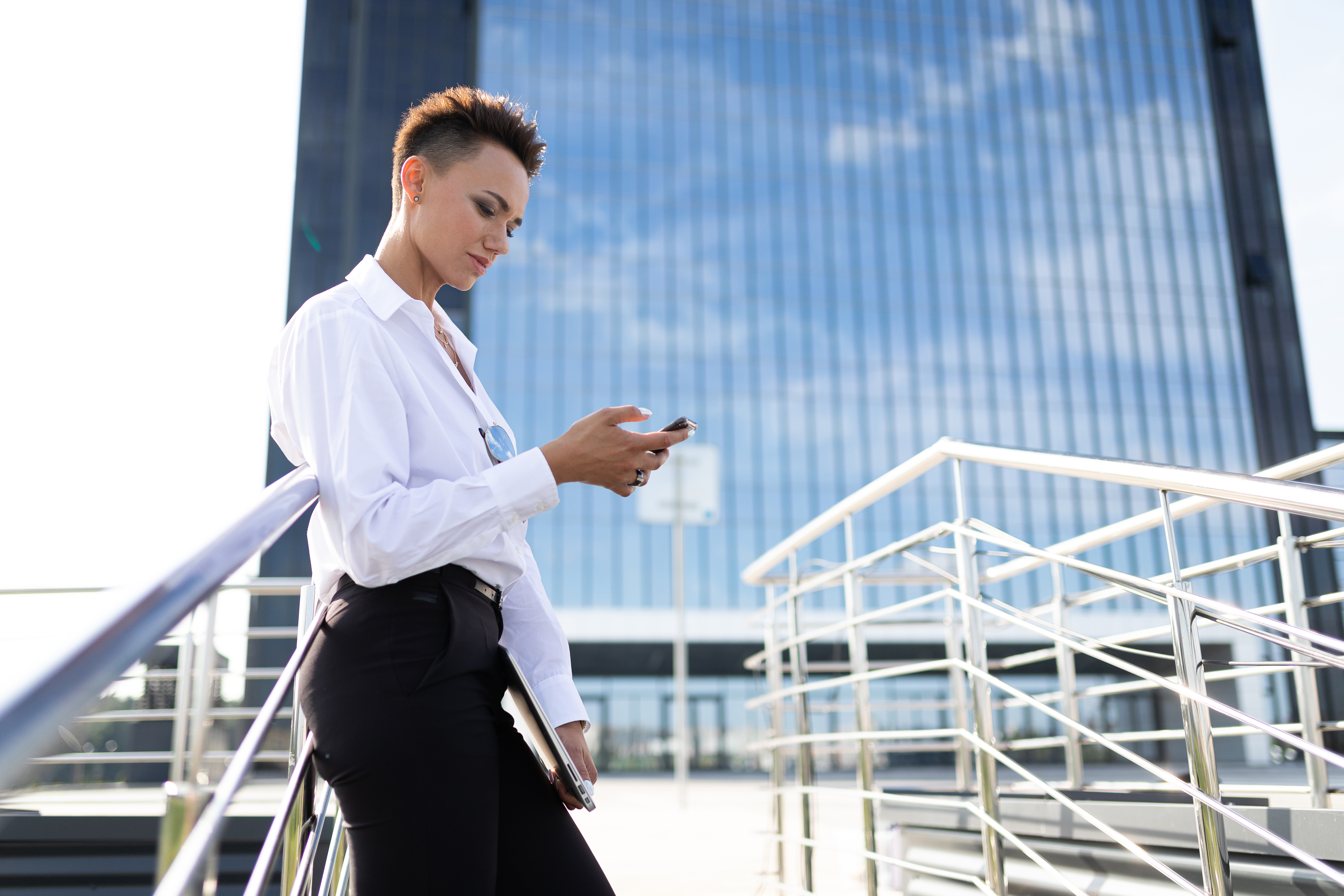 Young people on smartphones in a bright European plaza